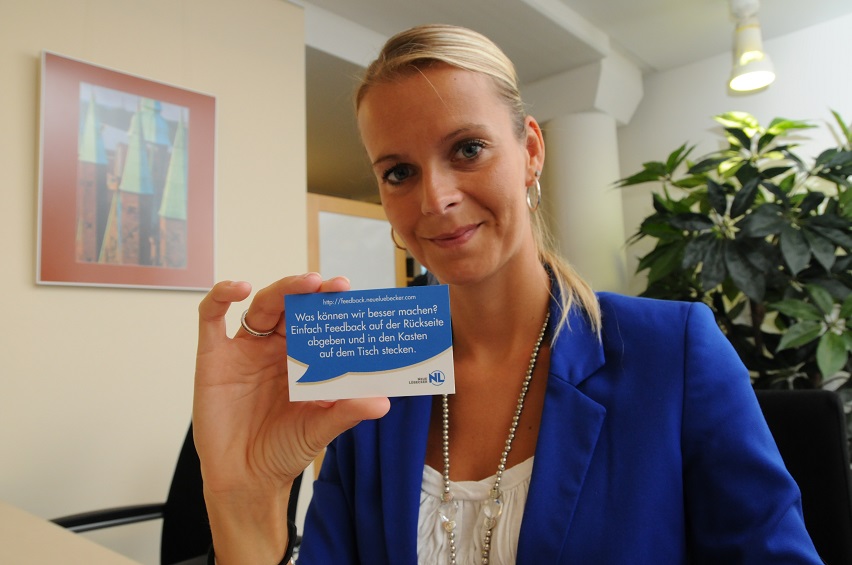 Frau mit Karte für das neue Feedbacksystem der Neue Lübecker